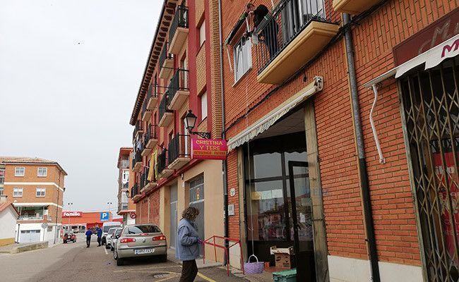 Un hombre comprando a través de una cesta y una cuerda, desde el balcón de su casa.