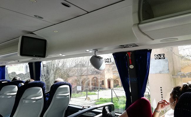Una joven observa el campamento de Monte la Reina a través de la ventana del autobús.