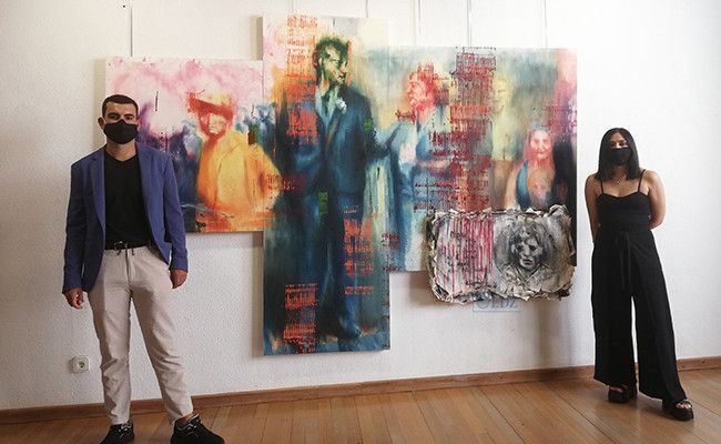 Artista y comisaria posando en uno de los cuadros.