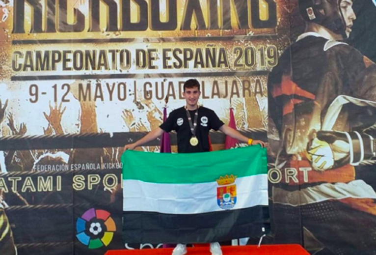 Julián Lozano posa con la bandera de Extremadura tras su consecución del campeonato de España (Foto: Federación Extremeña de Kickboxing y Muaythai)