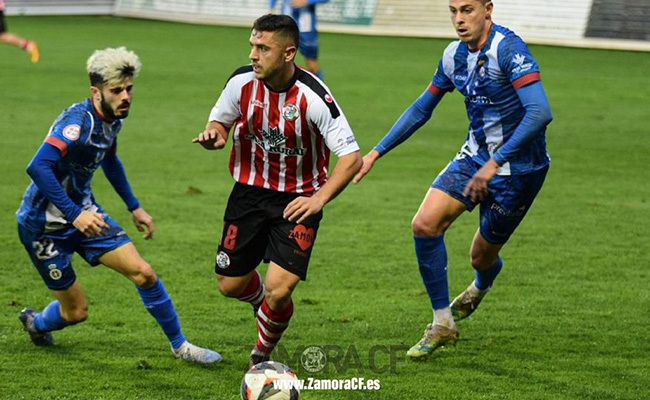 Pau Miguélez, encimado por Isi Ros. El rojiblanco, expulsado, el asturiano, en el descuento