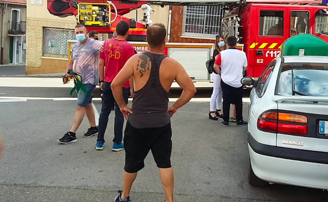 Los dos valientes vecinos, de espaldas, observando el trabajo de los Bomberos