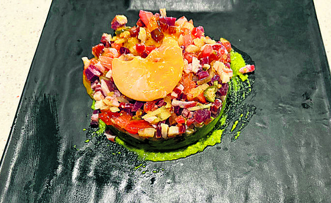 Steak tartar de jamón y ibérico, sobre cama de aguacate, coronado con yema de huevo de codorniz