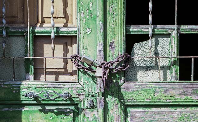 Puerta cerrada con cadenas para evitar el saqueo de las casas abandonadas en el municipio de La Tabla